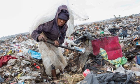 Fanja Randriamihavo, 15, sifts through rubbish at Ralalitra during heavy rain