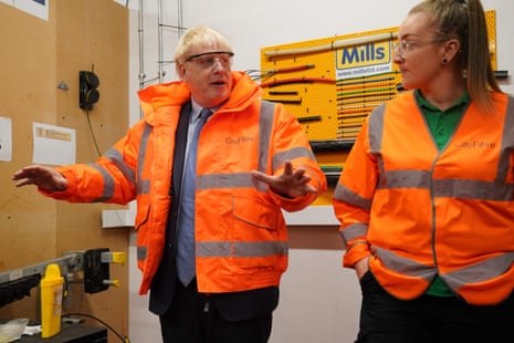 Britain’s Prime Minister Boris Johnson (L) gestures during a visit to CityFibre Training Academy in Stockton-on-Tees, in north-east England on May 27, 2022.