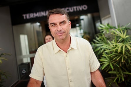 Flávio Bolsonaro leaves a building after casting his vote. He has short greying brown hair and wears a short-sleeved pale yellow cotton shirt.
