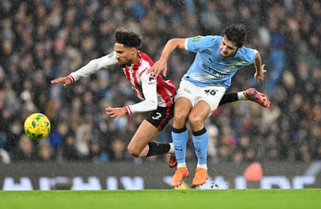 Brentford's Kevin Schade is felled by Manchester City's Abdukodir Khusanov.