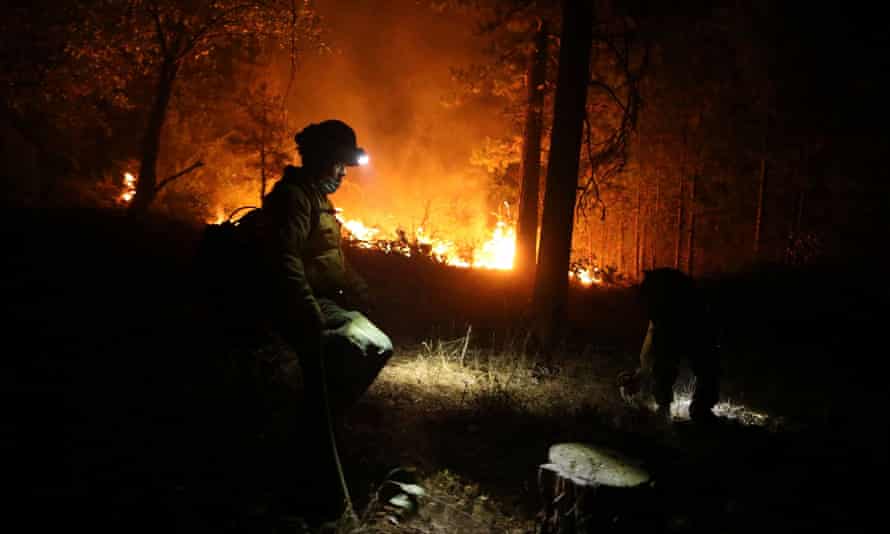 A member of a ground crew works as more structures are burned by the Dixie Fire near Greenville, in Indian Valley, California, US, on 9 August, 2021.