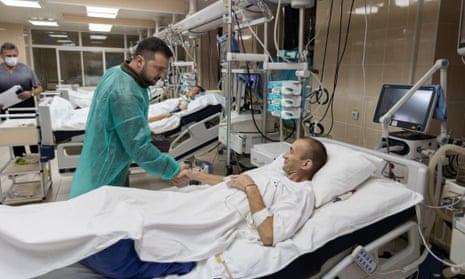 Volodymyr Zelenskiy, left, meets an injured Ukrainian serviceman during a visit to a military hospital in Kyiv on Friday