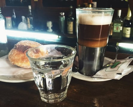 Cup of coffee and glass of water on the bar at El Simbolo, Buenos Aires, Argentina