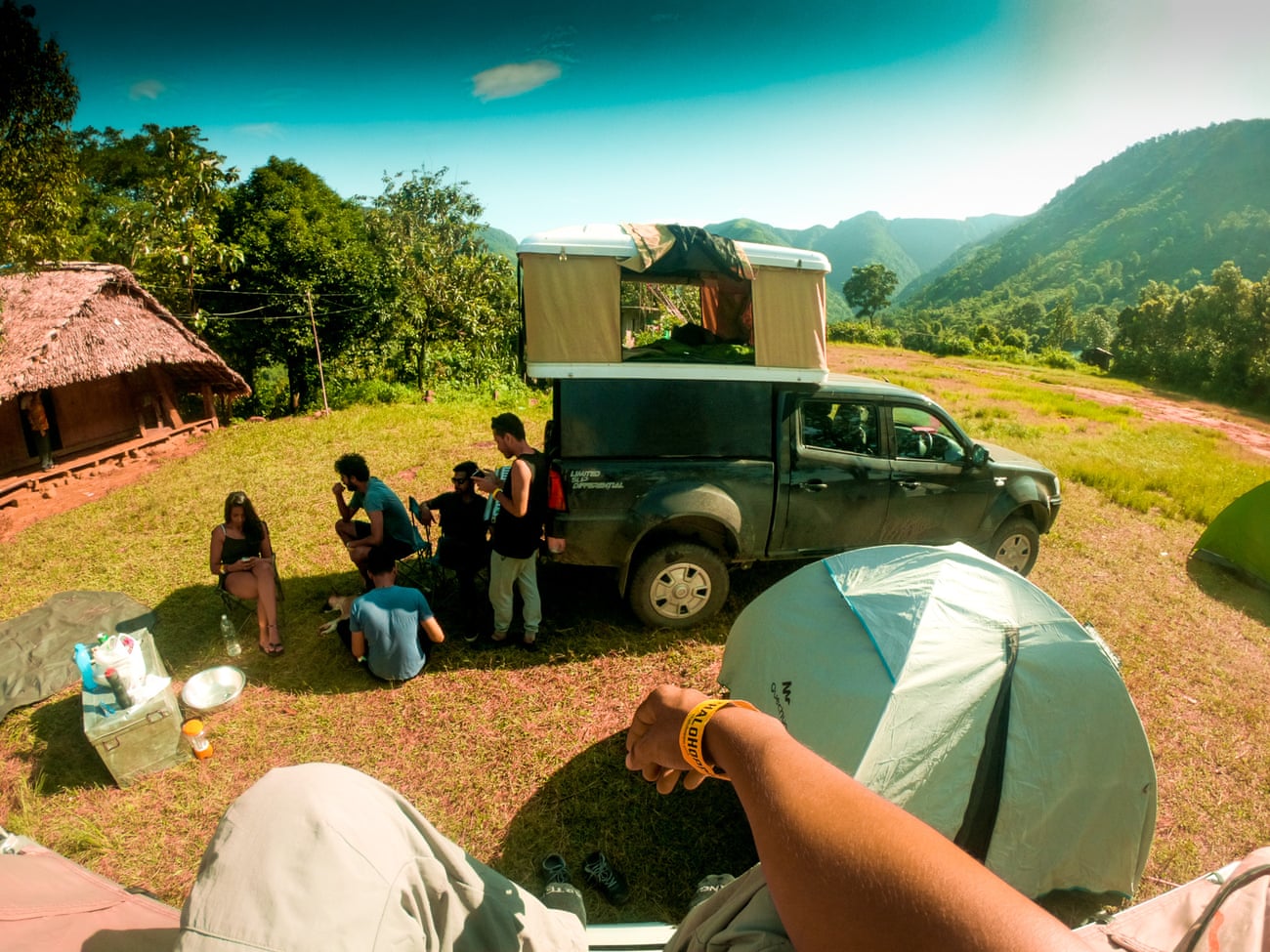 Young people camp next to their campervan among hills in India