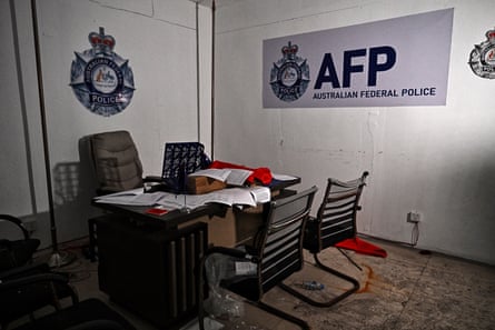 A room with a table and four chairs and signs on the wall imitating Australian Federal Police signs