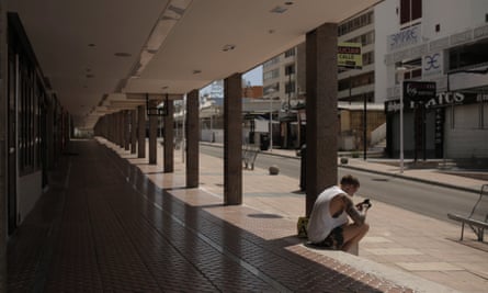 Tourism and Coronavirus A man sits in an empty street in Magaluf.