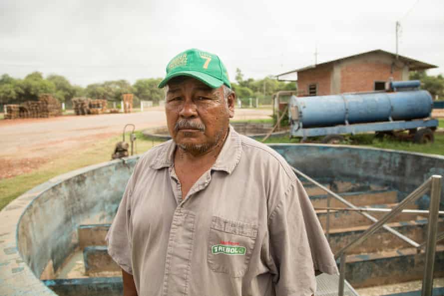 Rocky road: Paraguay’s new Chaco highway threatens rare forest and last of the Ayoreo people | Global development 16 A man in a baseball cap and a work shirt stands in front of machinery looking at the camera.