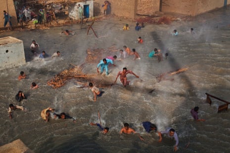 Flood victims scramble for food rations as they battle the downwash from a Pakistan Army helicopter during relief operations on September 13 2010 in the village of Goza in Dadu district in Sindh province, Pakistan