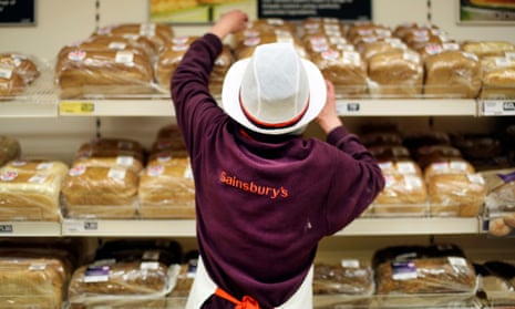 A Sainsbury's worker replenishes the bread aisle