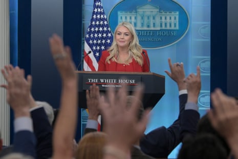 a woman in front of people rising their hands