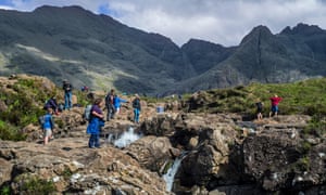 Tourists at the fairy pools, a group of waterfalls in Glen Brittle on the Isle of Skye
