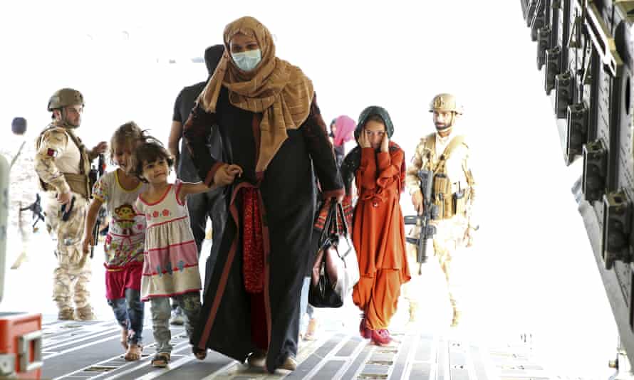 Afghans board a Qatari transport plane as they are evacuated from Afghanistan.
