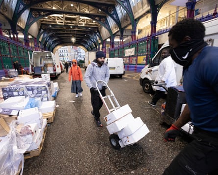 People push trolleys with boxes at Smithfield market
