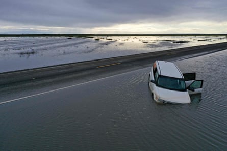 Kendaraan yang terendam sebagian setelah banjir di Central Valley di daerah Tulare dekat Allensworth, California.