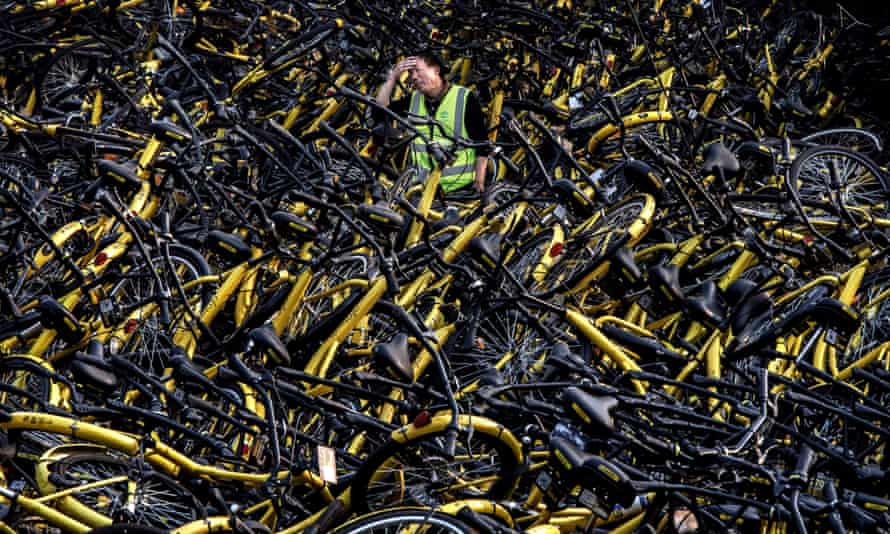 A mechanic from bike share company Ofo stands amongst damaged bicycles needing repair in Beijing.