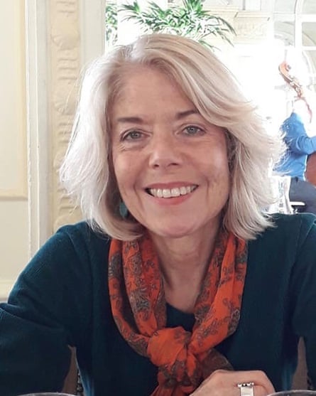 Photo of Hilary Ellis wearing a black top and scarf, smiling at the camera