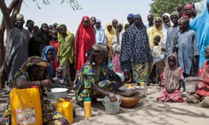 Local cereal vendors are seen with displaced people at an IDP camp in Dikwa, Borno state, Nigeria