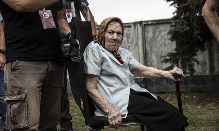 An elderly woman waits to board a train in Pokrovsk