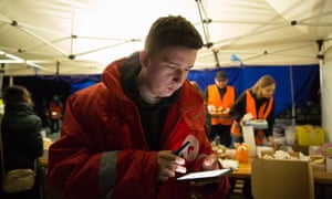 Mykhailo, a Red Cross volunteer, receives information on his mobile phone during a shift near the Ukrainian-Slovak border late in the night in Uzhhorod, Ukraine.