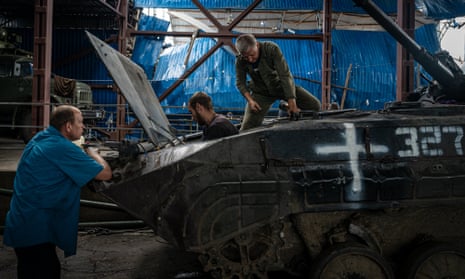 Disguised as civilians and at an undisclosed location, Ukrainian soldiers fix a soviet-era armoured vehicle damaged by the war in Donetsk Oblast.