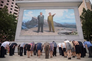 People bow before a portrait of Kim Il-sung and Kim Jong-il in Pyongyang, North Korea