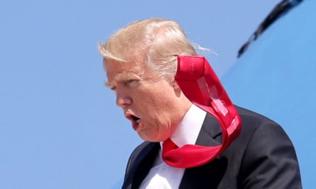 Donald Trump’s tie flaps in the wind, revealing sticky tape attached to the back, as he arrives at Orlando international airport on 3 March 2017.