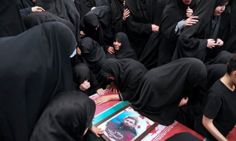 In this photo released by an official website of the office of the Iranian supreme leader, families mourn over the flag-draped coffins of the Iranian Revolutionary Guards members who were killed in an airstrike in Syria on Monday widely blamed on Israel.