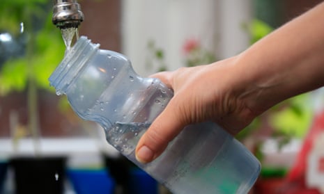 A plastic bottle being filled with water