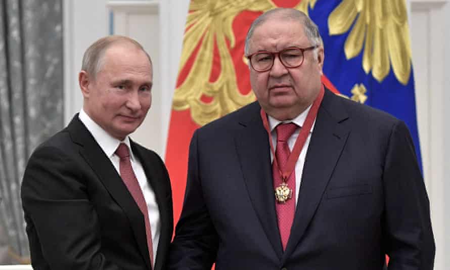Vladimir Putin, a la izquierda, le da la mano a Alisher Usmanov  