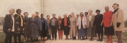 A yellowed photograph of a group of Black and white women standing in a line