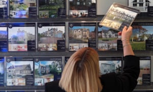 A woman looking at houses for sale in an estate agents in Edinburgh