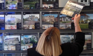 A woman looks at properties for sale in an estate agents in Edinburgh