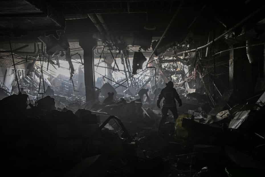 A Ukrainian serviceman walks between debris inside the Retroville shopping mall after a Russian attack on the north-west of the capital Kyiv on March 21
