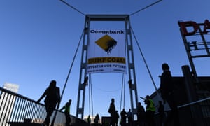 Activists unveil a banner in Sydney in May protesting coal financing by the Commonwealth Bank.
