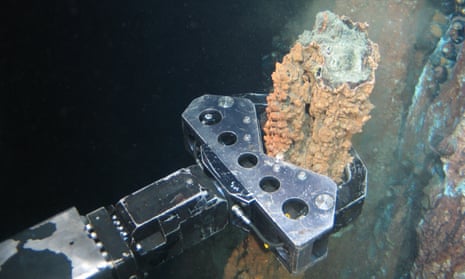  A robotic arm breaks off a chunk of mineral-rich rock for sampling deep underwater off the coast of Papua New Guinea. 