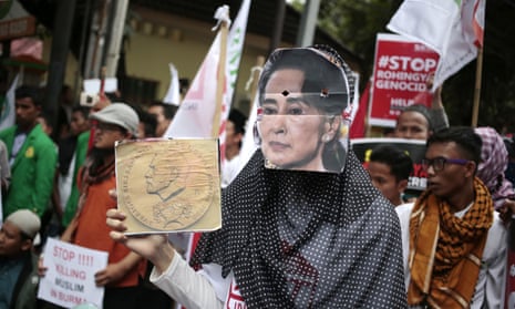 A Muslim woman wears an Aung San Suu Kyi mask during a rally against the persecution of Rohingya.