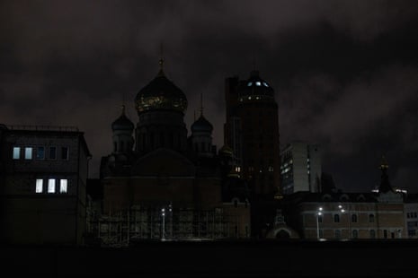 Dark street and buildings with only a few lights showing