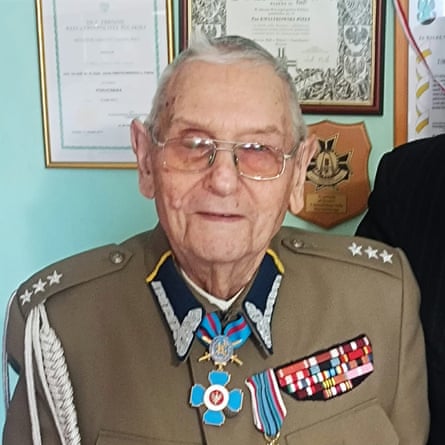 Józef Kwiatkowski, an elderly man with thin grey hair and glasses, wearing a soldier’s uniform with a medal around his neck