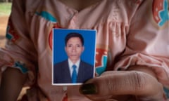 Nhu Laen’s widow, Kwak Nga, shows a photograph of her husband, who took his own life in 2022 while the couple owed thousands to LOLC Cambodia, a microfinance company.