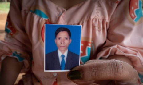Nhu Lien’s widow, Kwak Nga, shows a photograph of her husband, who took his own life in 2022 while the couple owed $18,600 to LOLC Cambodia, a microfinance company.