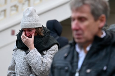 Mourners stand outside the headquarters of Charles University after mass shooting in Prague, Czech Republic, Friday, Dec. 22, 2023.