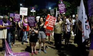 Israelis hold placards in protest against the legislation