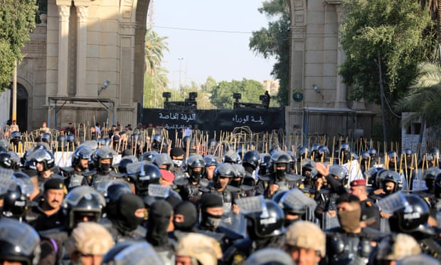 قوات الأمن العراقية تقوم بالحراسة بينما يحاول المتظاهرون اقتحام المنطقة الخضراء.