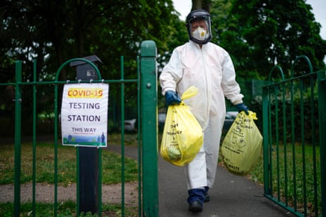 A city council worker carries rubbish from a coronavirus testing centre at Spinney Park on 29 June, 2020 in Leicester, England.