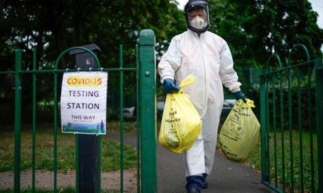 A city council worker carries rubbish from a coronavirus testing centre in Leicester.