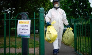 A city council worker carries rubbish from a coronavirus testing centre at Spinney Park which will be incinerated on 29 June 2020 in Leicester, England.