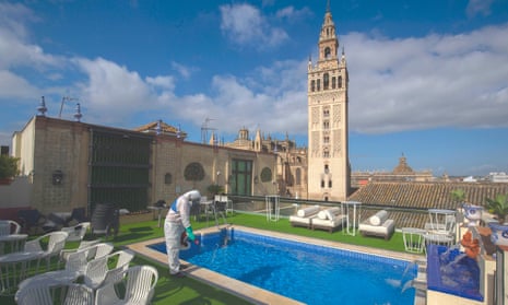 A worker desinfecting the terrace of hotel in Seville,.