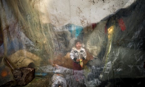 A child shelters from the rain under plastic sheeting in the refugee camp at Idomeni on Greece’s northern border, in 2016.