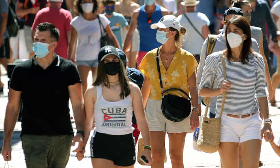 People wearing face masks to protect against coronavirus walk down the street in Saint Jean de Luz, southwestern France.