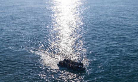 An inflatable boat filled with people surrounded by an expanse of open water.